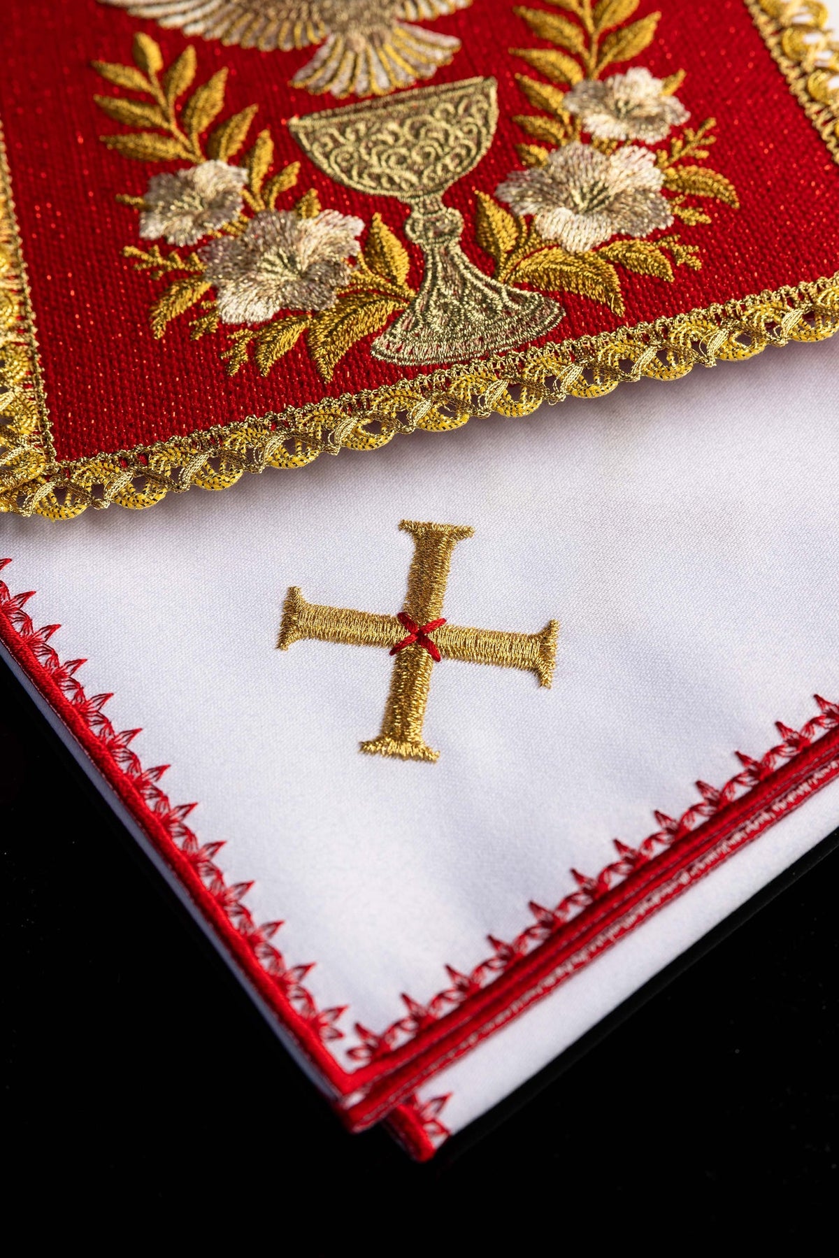 Bielizna kielichowa – biała tkanina z haftowanym złotym krzyżem i czerwonym wykończeniem